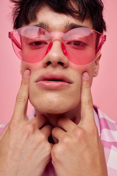 portrait of a young man fashionable pink sunglasses jacket posing pink background unaltered - Foto, afbeelding
