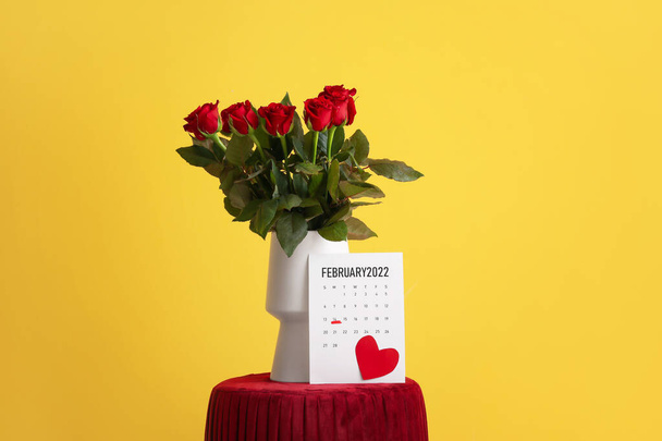 Buquê de flores e calendário com data marcada do Dia dos Namorados no fundo de cor - Foto, Imagem