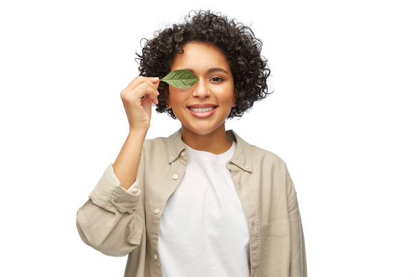 smiling woman holding green leaf - Zdjęcie, obraz