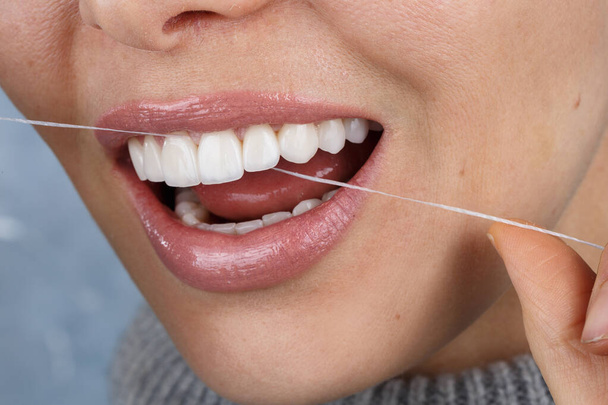 ženský úsměv a nitě pro každodenní ústní hygienu - Fotografie, Obrázek