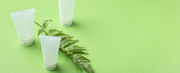 Hautpflege Bio-Kosmetikflaschen, Pflanzenblätter auf grünem Hintergrund - Foto, Bild