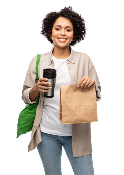 happy woman with thermo cup, paper bag and shopper - 写真・画像