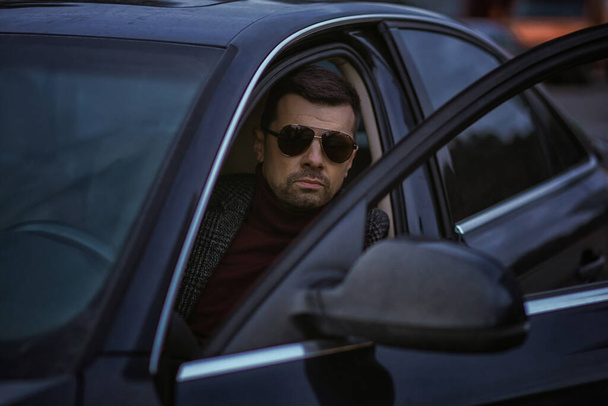 Retrato de negocios de un hombre en un coche. De moda prestigioso chico. - Foto, Imagen