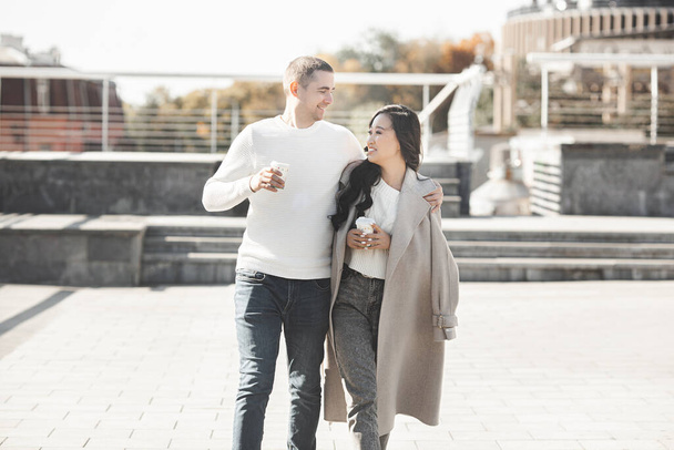 Young pretty couple walking on city background. Woman and man together having fun on urban background. Lovely young people dating. - Foto, immagini