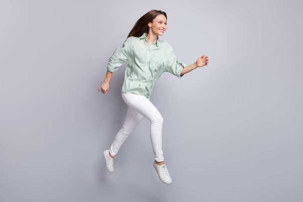 Full body profile photo of impressed brunette lady run wear blouse trousers sneakers isolated on grey color background - Foto, immagini