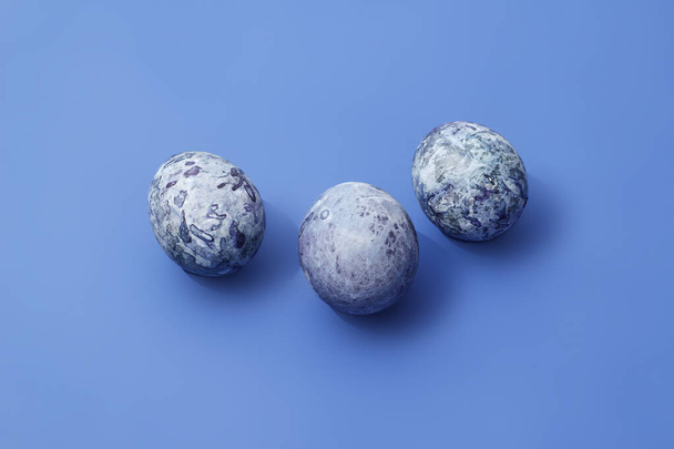 Easter marbled purple eggs on blue background. - Photo, Image
