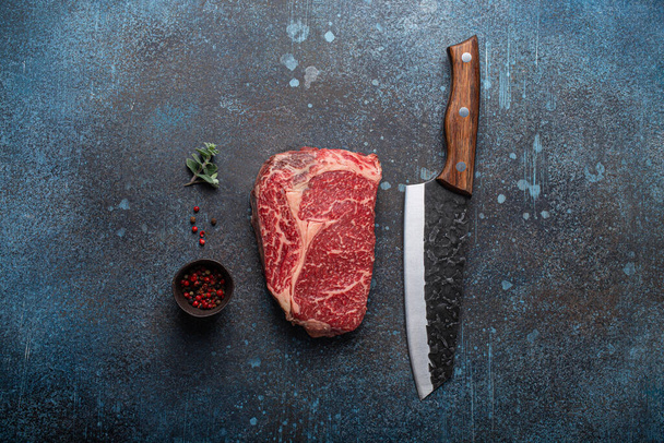 Rauw vlees rundvlees gemarmerd eersteklas steak Ribeye op rustieke betonnen keukentafel - Foto, afbeelding