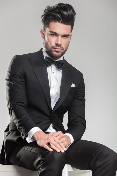 Attractive young man wearing tuxedo sitting  - Foto, imagen
