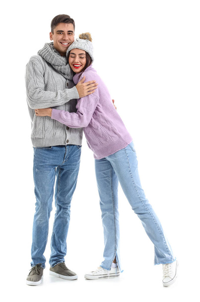 Boldog fiatal pár meleg pulóverben fehér háttéren - Fotó, kép