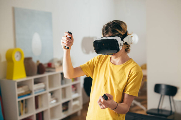 teenager boy using virtual reality glasses at home - Foto, afbeelding