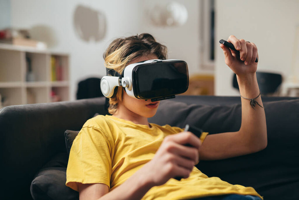 teenager boy using virtual reality glasses at home - Foto, Imagem