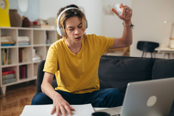 Мальчик-подросток учится онлайн из дома. he is angry - Фото, изображение