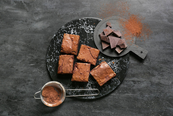 Πίνακας με κομμάτια νόστιμο brownie σοκολάτα σε μαύρο φόντο - Φωτογραφία, εικόνα