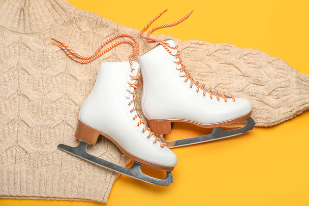 IJsschaatsen en trui op oranje achtergrond - Foto, afbeelding