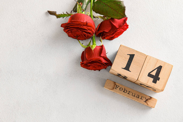 Kalender mit Valentinstag-Datum und roten Rosen auf weißem Hintergrund - Foto, Bild