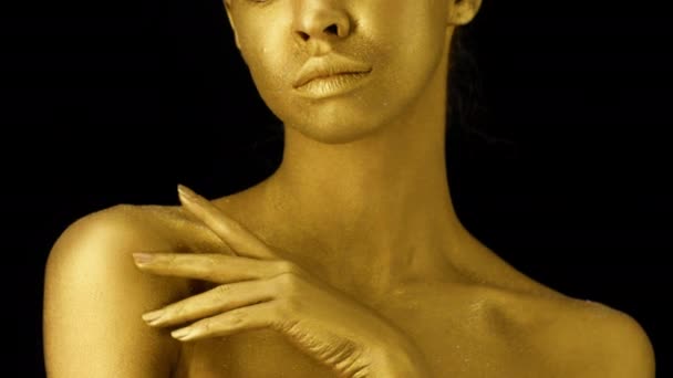 Woman With Golden Skin Stroking Neckline Over Black Background, Cropped - Footage, Video