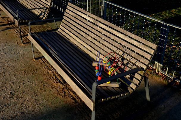 ogrodzenie placu zabaw wykonane z ocynkowanych balustrad z bramą przed psami. społeczność piaskownica z darowizny kolorowe zabawki puzzle. graniczy z drewnianymi belkami wokół piasku i kłody jak ławki - Zdjęcie, obraz