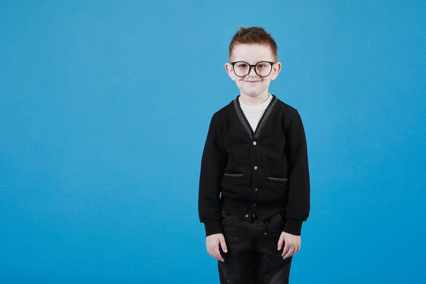 Little cute boy with glasses is smiling and having fun isolated on grey background. happy childhood. copy space. - Foto, Bild