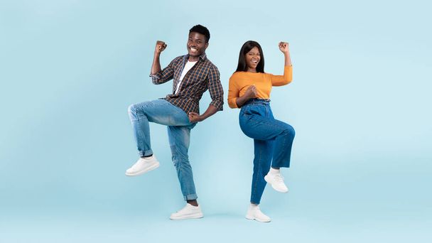 Portrait of excited young black couple shaking clenched fists - Foto, Imagen
