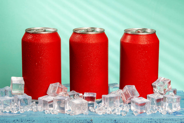 rote Getränkedose auf blauem Hintergrund und mit Eis und Kälte - Foto, Bild