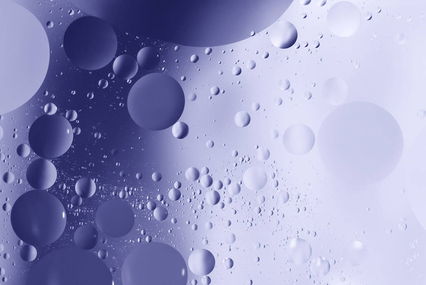 oil with bubbles on on dark blue background. Abstract background. - Foto, Imagen