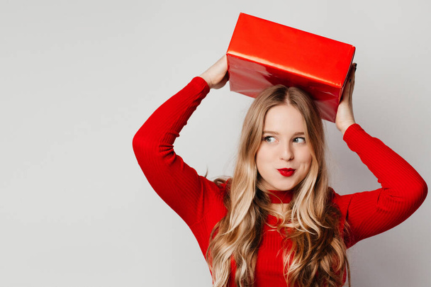 Close up photo of interested young woman waiting for her boyfriend, wearing red clothes isolated over white background - Fotografie, Obrázek