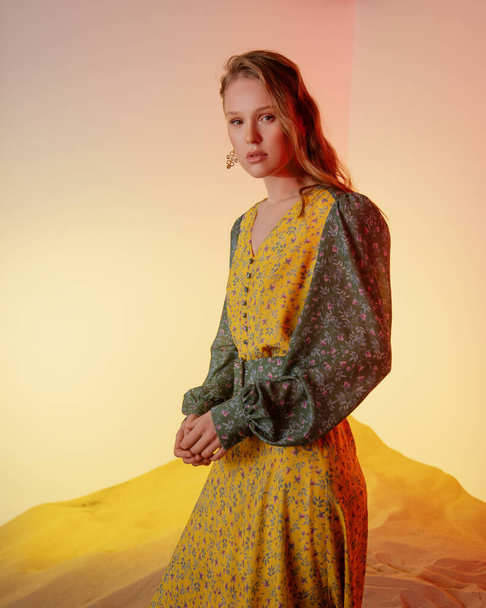 jeune beau modèle posant en studio. femme en robe jaune. mode créative éclairage couleur. - Photo, image