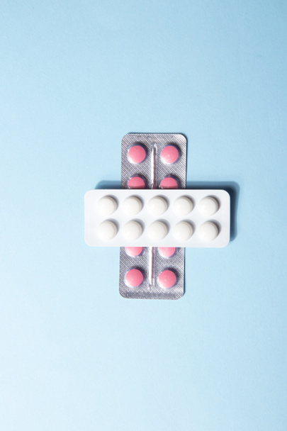 Zwei Packungen Tabletten in Blasen auf blauem Hintergrund. Nahrungsergänzungsmittel und Pillen für Diäten. Vitamintabletten. Medizinisches Konzept. Vertikal flach gelegt - Foto, Bild