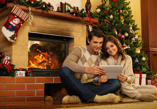 クリスマス装飾家インテリアで暖炉のそばのカップル  - 写真・画像