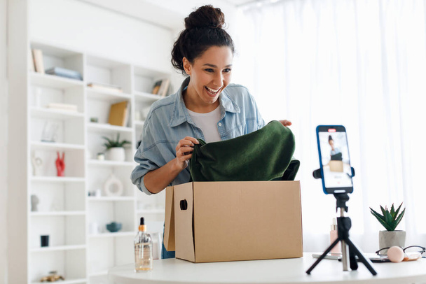 Γυναίκα blogger Κάνοντας βίντεο ξεπακετάρισμα κουτί με νέα ρούχα Εσωτερική - Φωτογραφία, εικόνα