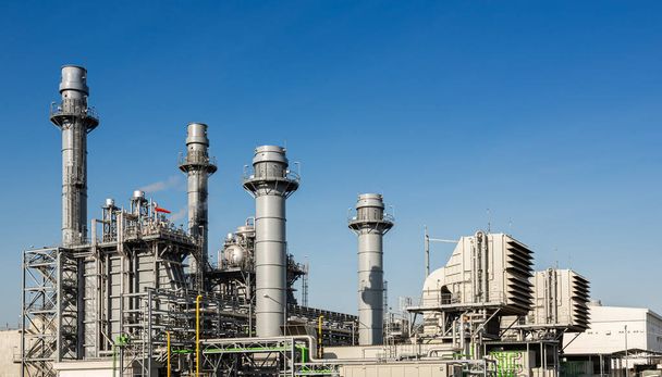 Budova elektrárny a průmyslový potrubní systém na pozadí modré oblohy - Fotografie, Obrázek