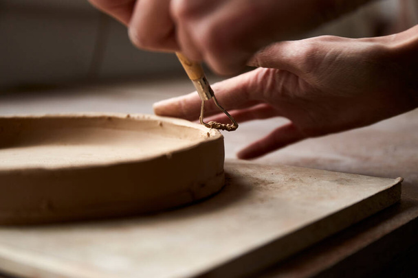 Ceramista feminina a trabalhar no estúdio de cerâmica. Mãos de Ceramista Sujas de Argila. Processo de criação de cerâmica. Mestre ceramista trabalha em seu estúdio - Foto, Imagem