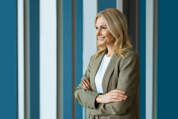 Beautiful and cheerful mature adult senior woman standing in the office - Portrait of successful corporate businesswoman with formal elegant dress - Fotografie, Obrázek