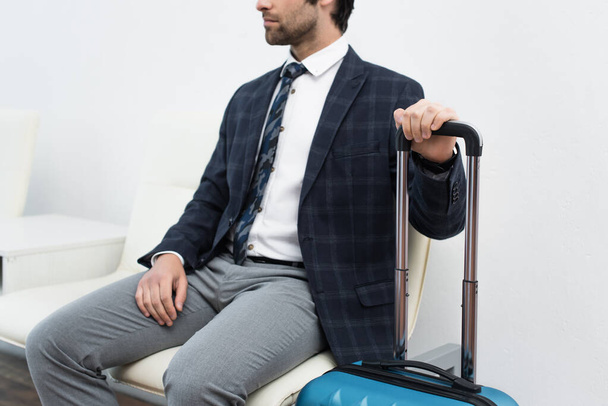 cropped view of man with travel bag waiting in departure lounge - Foto, Imagen