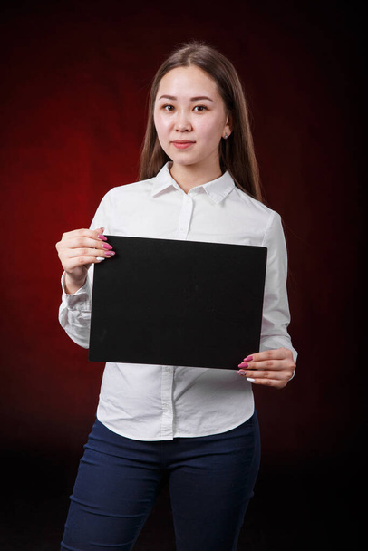 Asian girl holding sign on black background - Foto, Imagen