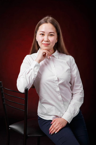 Businesswoman sitting on a chair isolated on black background - Foto, Imagen