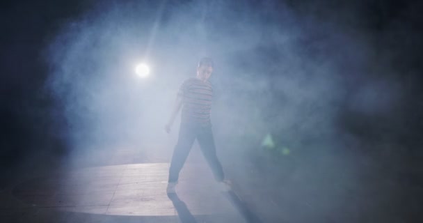 Mladá žena tanečnice provádějící hip hop tanec ve zpomaleném filmu se světlem a kouřem pozadí - Záběry, video