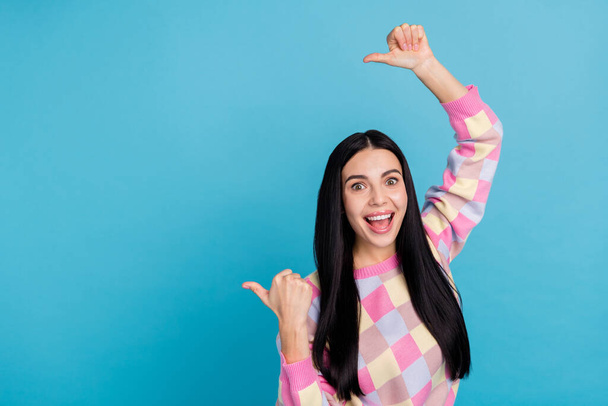 Photo of funny excited lady dressed print pullover pointing thumbs back empty space isolated blue color background - Fotoğraf, Görsel