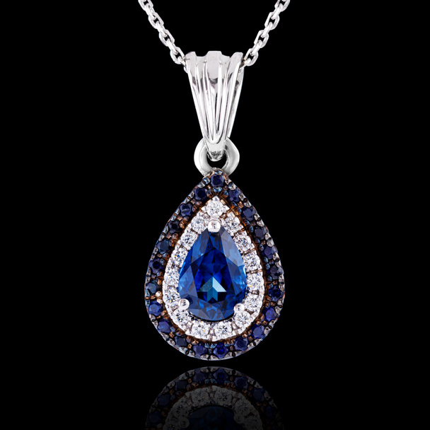 beautiful pendant with sapphire with a gold chain on a black background close-up - Photo, Image