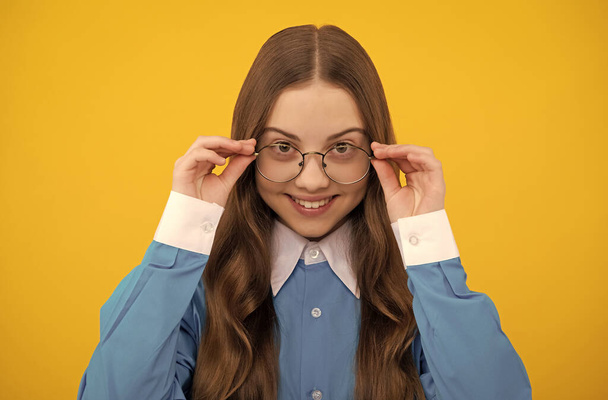 Mutlu okul çağındaki kız gözlük takıyor sarı arka plan, görme - Fotoğraf, Görsel