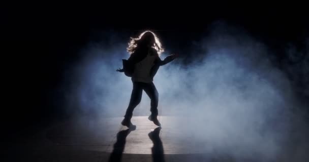 Молодая танцовщица исполняет дикий хип-хоп танец на фоне стробоскопа и дыма - Кадры, видео