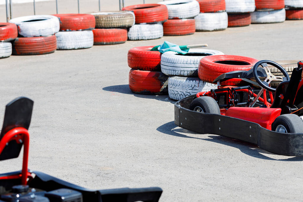 Rennwagen auf einer von roten Reifen begrenzten Kartbahn. Kart Autovermietung zum Spaß - Foto, Bild