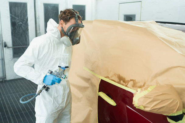 Pintor automático con pistola de pulverización en cabina de pintura de coches - Foto, imagen