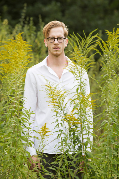 young man between flowers - Photo, Image