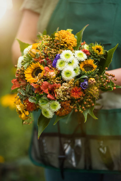 Florist holds flower bouquet in hand - Photo, Image