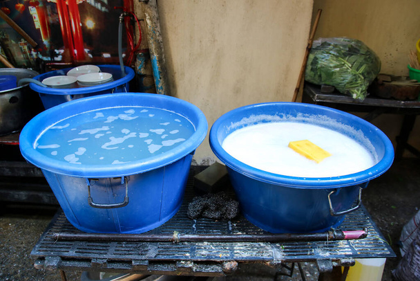 Две раковины положили воду и жидкость для мытья посуды для очистки использованного блюда в ресторане - Фото, изображение