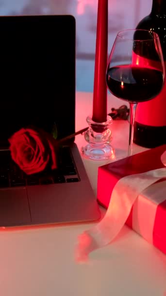 online dátum koncepció piros gyertya üveg bor és ajándék előtt laptop - Felvétel, videó
