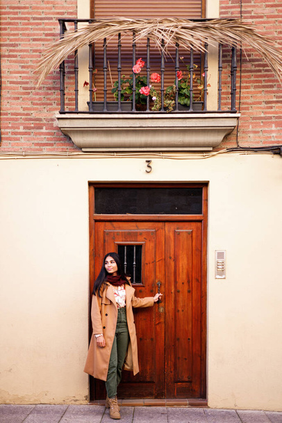beautiful young indian woman closing her home door in the morning to go for a walk - Zdjęcie, obraz