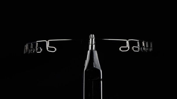 excelente composición de un arco ortodóncico de acero sobre fondo negro, al estilo del minimalismo - Foto, imagen