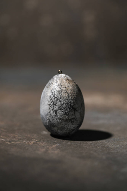 Little cotton wool egg colored with cracks dark mood for Easter - 写真・画像
